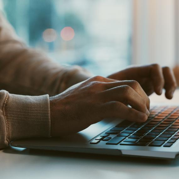 Shot of an unrecognizable businessman working on his laptop in the office